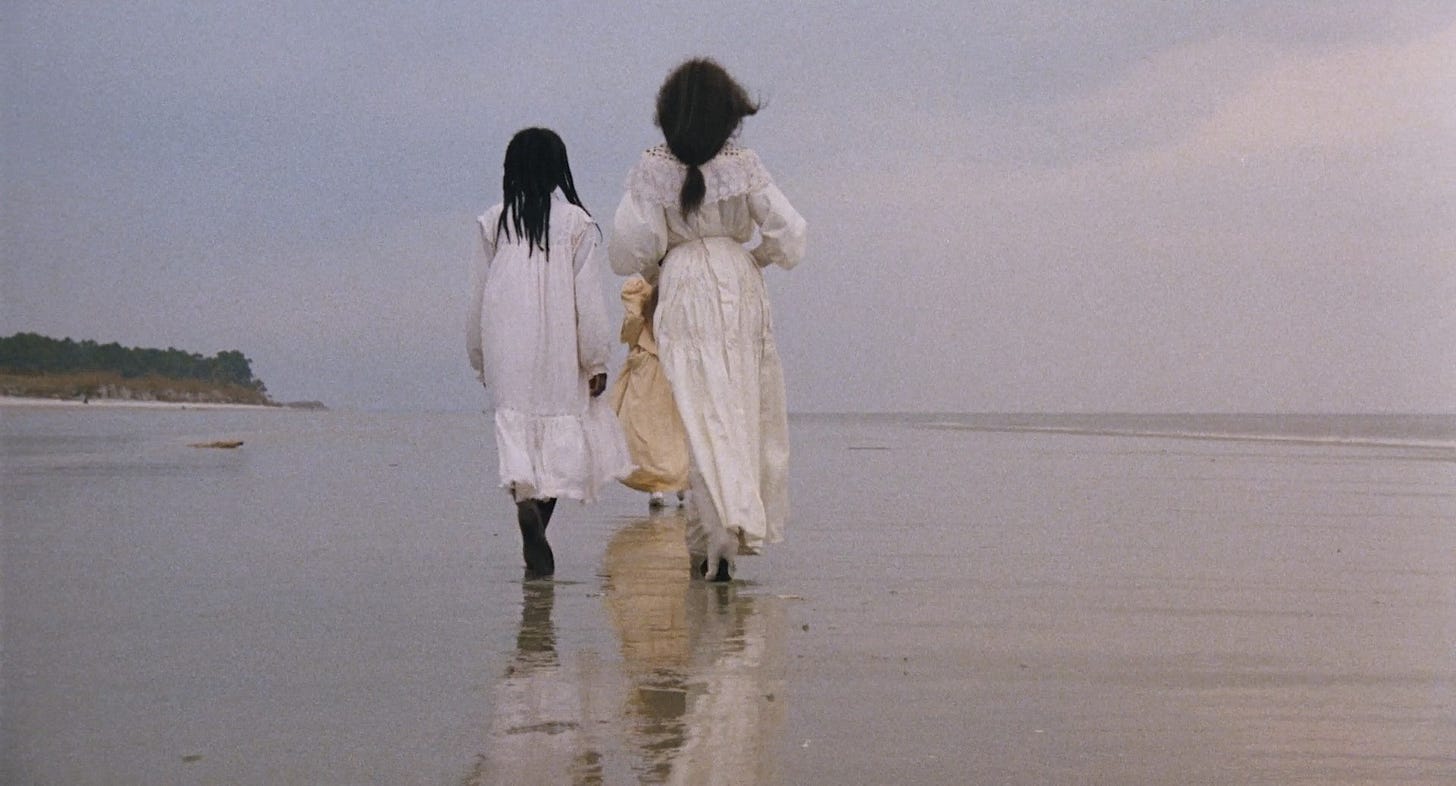 3 black women and white dresses with their backs toward the camera walking on a beach 3 black women and white dresses with their backs toward the camera walking on a beach