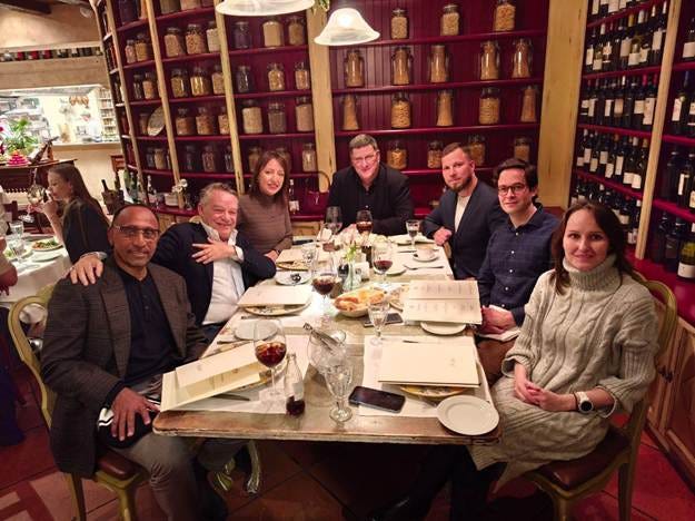 A group of people sitting around a table

AI-generated content may be incorrect.