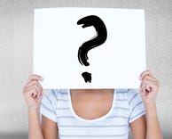 A woman holding a piece of paper in front of her face,. On the paper is drawn a question mark. A woman holding a piece of paper in front of her face,. On the paper is drawn a question mark.