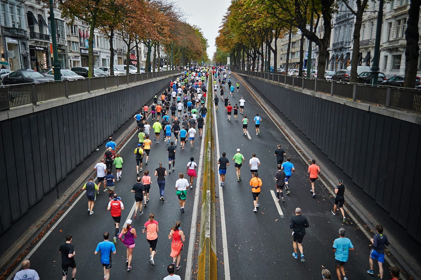 people running on a road during daytime people running on a road during daytime