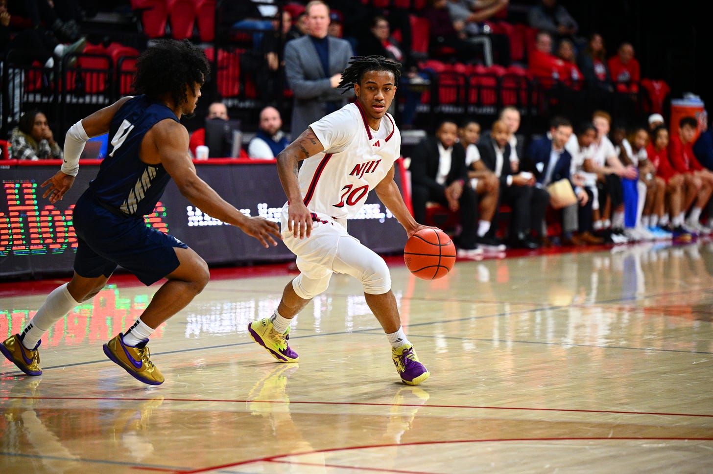 Tariq Francis drives with the ball while NJIT coach Grant Billmeier (back, center) looks on during a game against New Hampshire on Jan. 18, 2024. (Photo courtesy of NJIT Athletics) Tariq Francis drives with the ball while NJIT coach Grant Billmeier (back, center) looks on during a game against New Hampshire on Jan. 18, 2024. (Photo courtesy of NJIT Athletics)