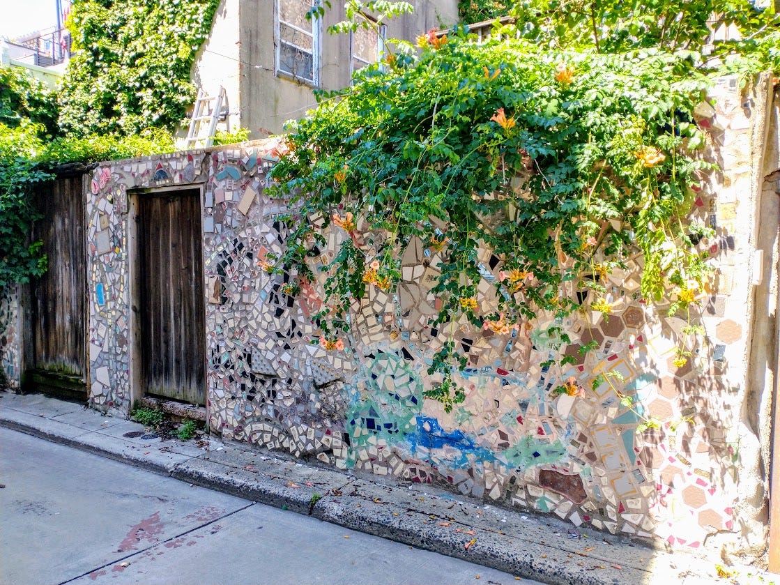 A garden wall covered with mosaics and supporting a massive trumpet vine growing over the top A garden wall covered with mosaics and supporting a massive trumpet vine growing over the top