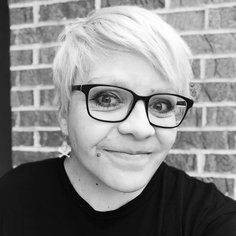 A black and white photo of a white woman wearing black glasses 