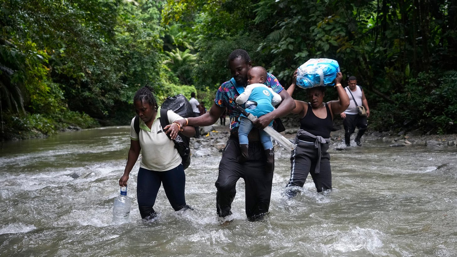 FILE - Haitian migrants wade through a river as they cross the Darien Gap, from Colombia into Panama, hoping to reach the U.S., Oct. 15, 2022. The United States, Panama and Colombia announced Tuesday, April 11, 2023, that they will launch a 60-day campaign aimed at halting illegal migration through the treacherous Darien Gap, where the flow of migrants has multiplied this year. (AP Photo/Fernando Vergara, File)