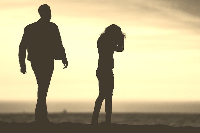 silhouette of man and woman under yellow sky