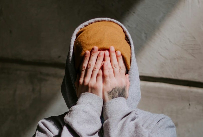 person in gray hoodie wearing brown leather shoes
