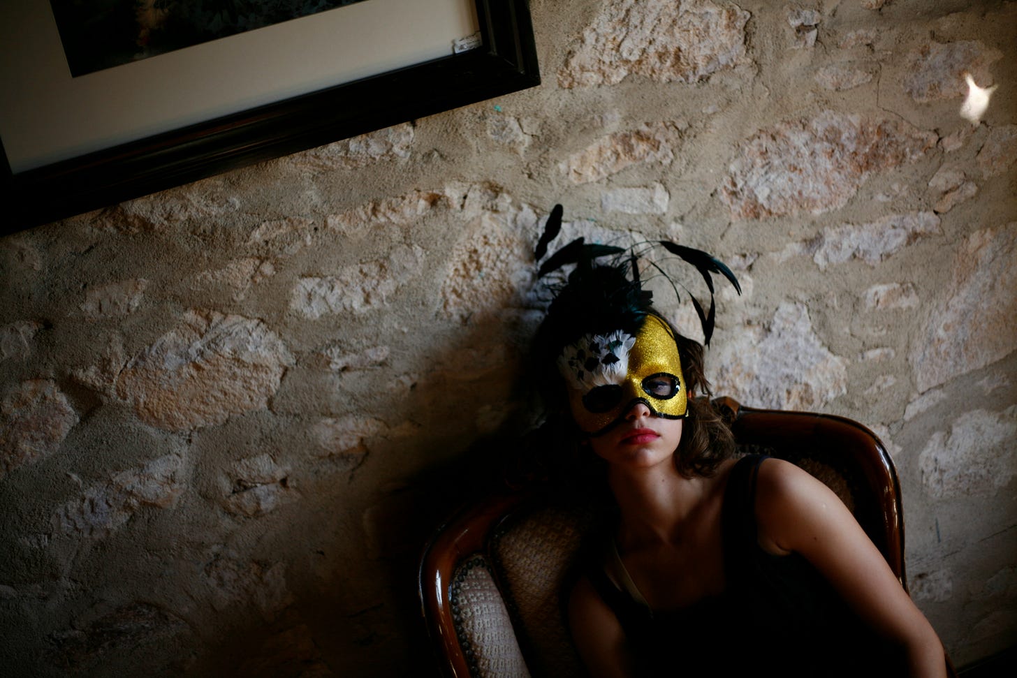 A woman sitting in a chair wearing a mask