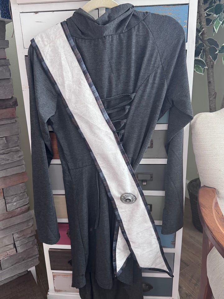 tartan trimmed cross body sash over grey dress