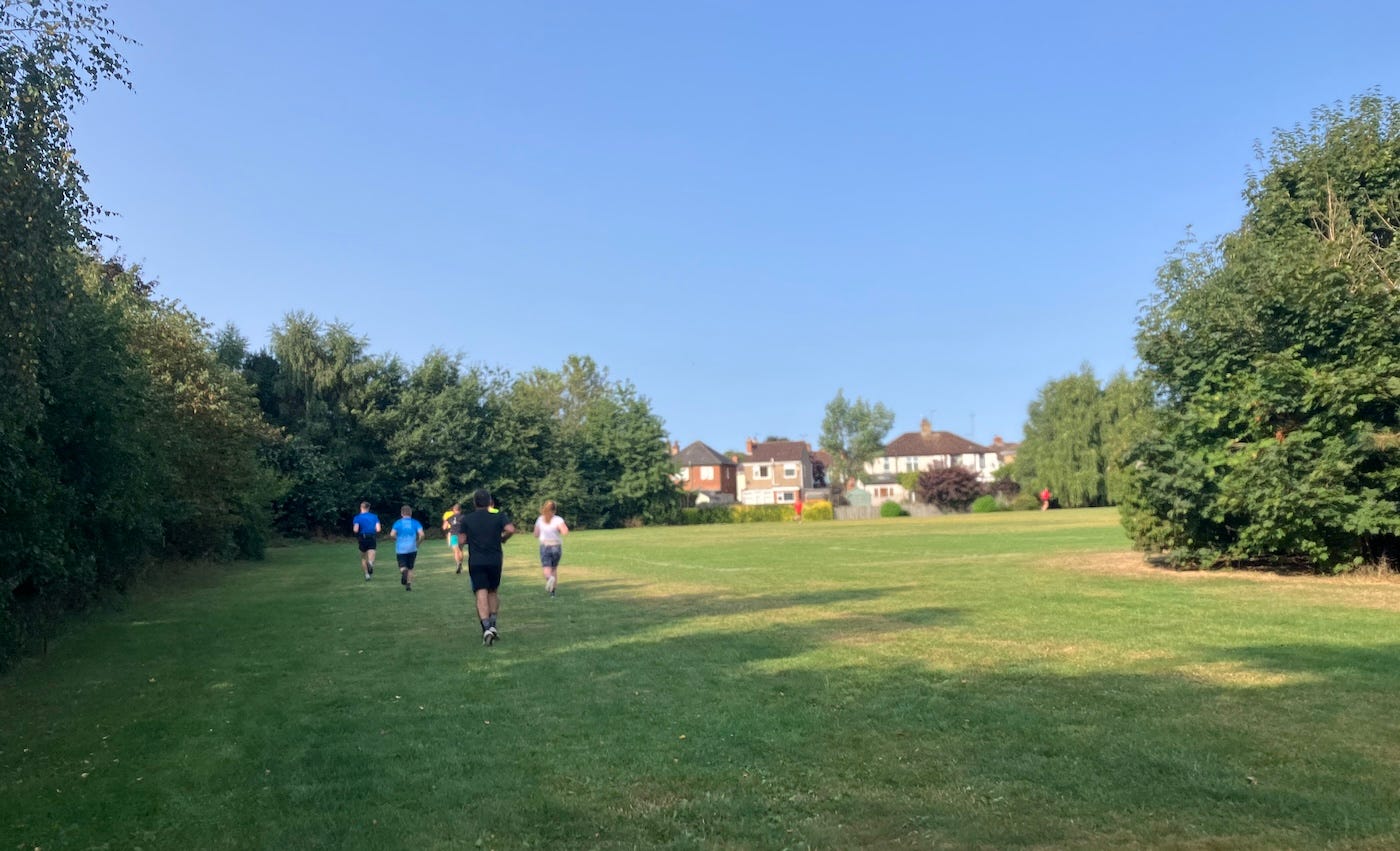 Runners on a field, passing trees