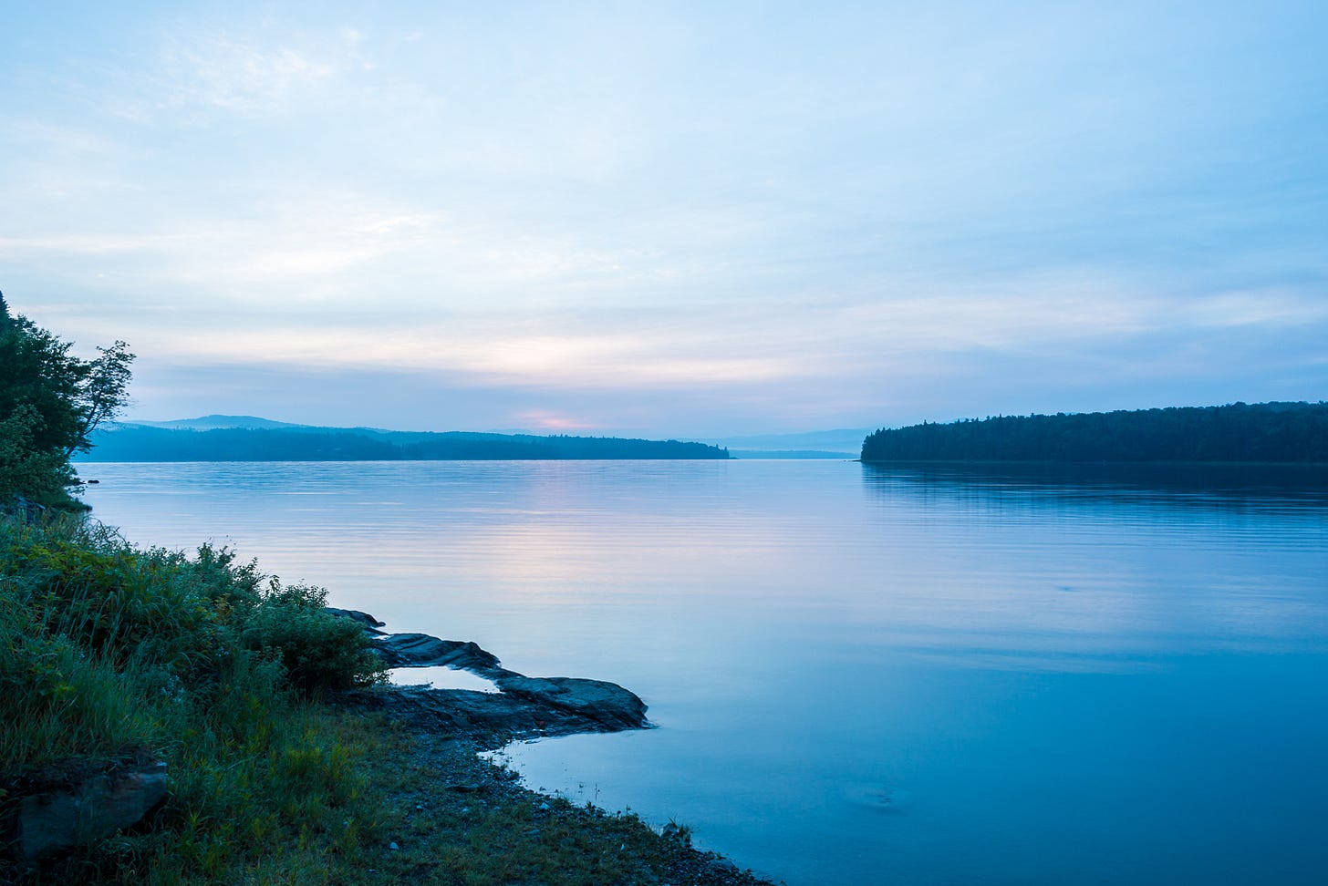 Calm lake with mountains in the distance.
