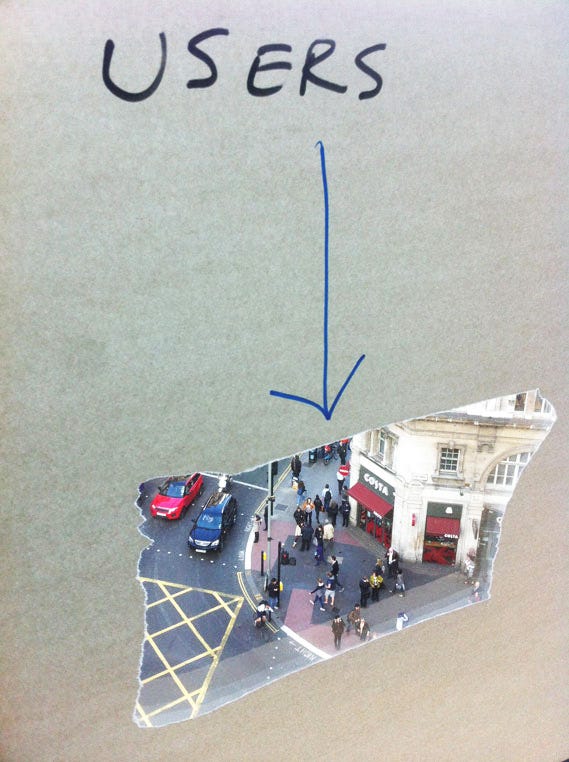 A photo of the âusersâ window. Someone stuck paper on a window, tore a hole in the centre of it, and wrote âUsersâ above it. The window (and the hole) overlooked the busy pedestrian crossing outside. A photo of the âusersâ window. Someone stuck paper on a window, tore a hole in the centre of it, and wrote âUsersâ above it. The window (and the hole) overlooked the busy pedestrian crossing outside.