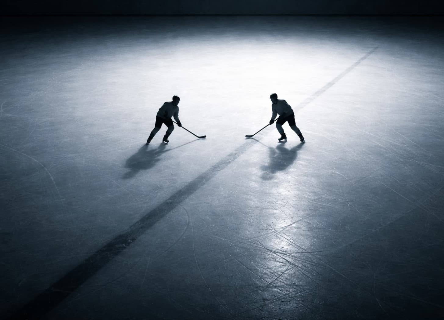 Two skaters as small dark figures, closing distance, with a strong diagonal line between them. Two skaters as small dark figures, closing distance, with a strong diagonal line between them.