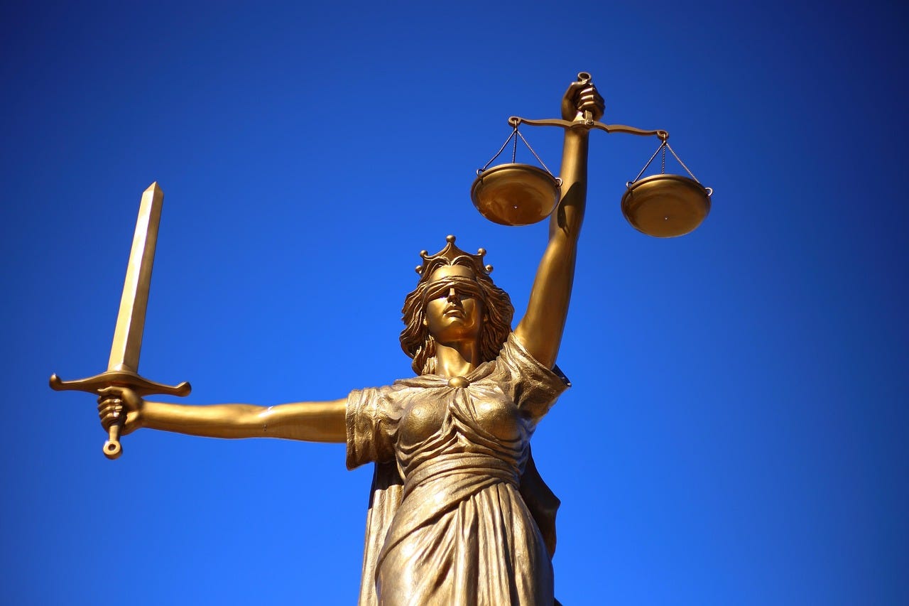 Bronze sculpture of blind justice, with scales in one hand and a sword in the other. Bronze sculpture of blind justice, with scales in one hand and a sword in the other.