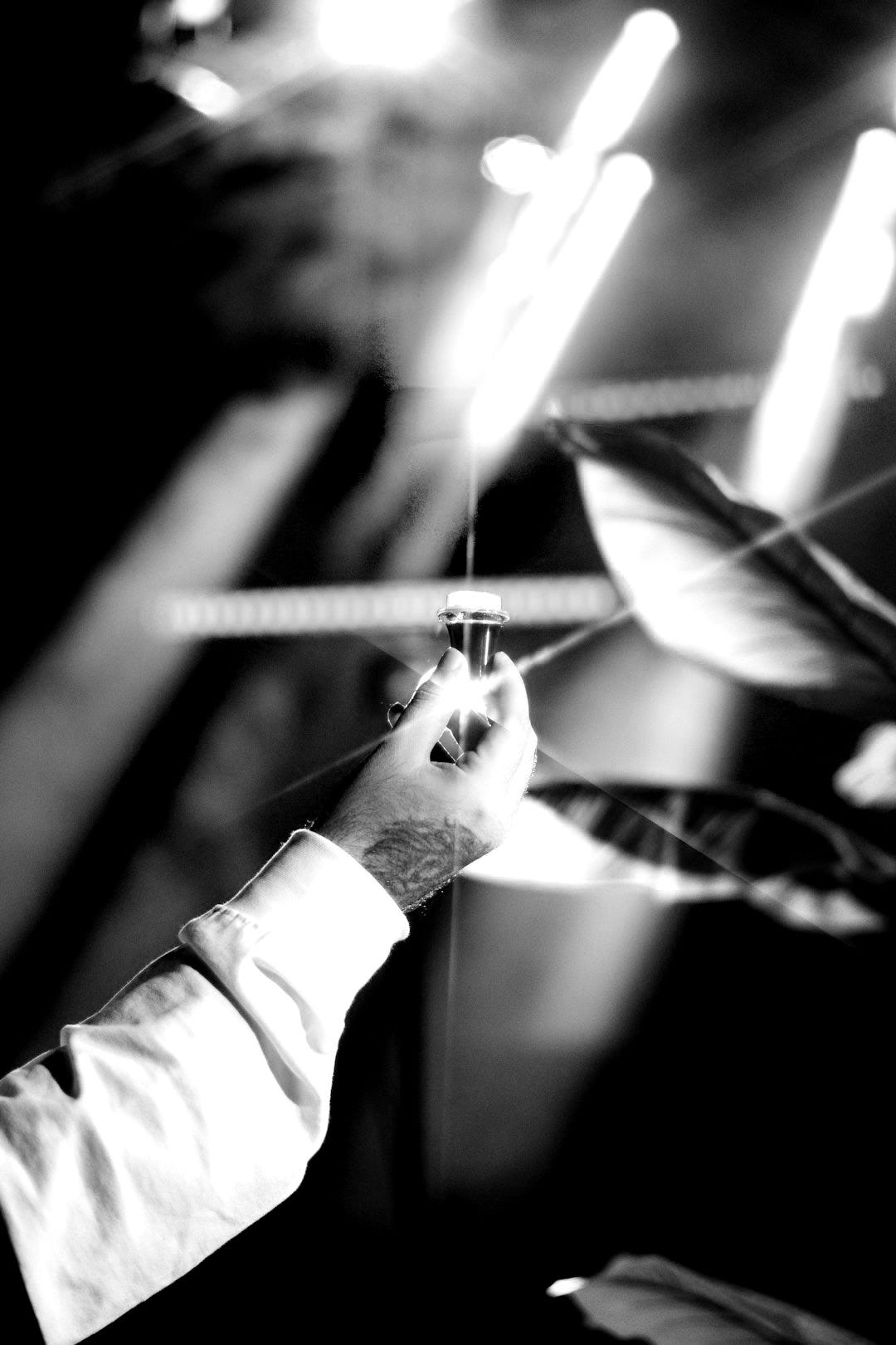 Hand holding small object with blurred lights background Hand holding small object with blurred lights background