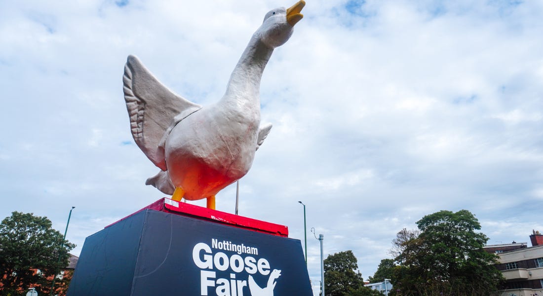 A goose statue on top of a black plinth with a sky above it A goose statue on top of a black plinth with a sky above it