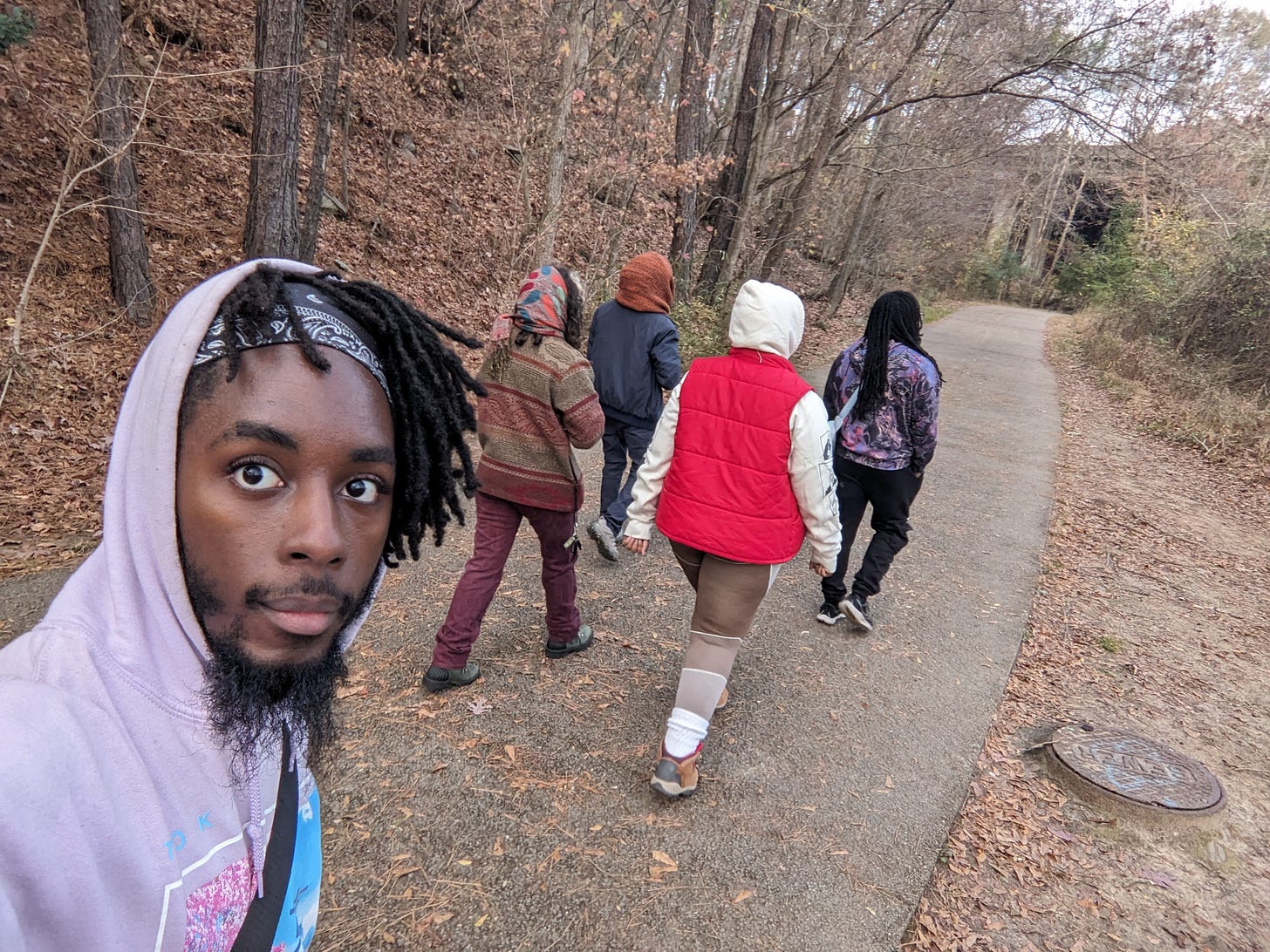 5 friends walking through an autumn wood hiking trail
