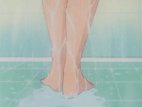 This may contain: the legs of a woman standing in front of a shower