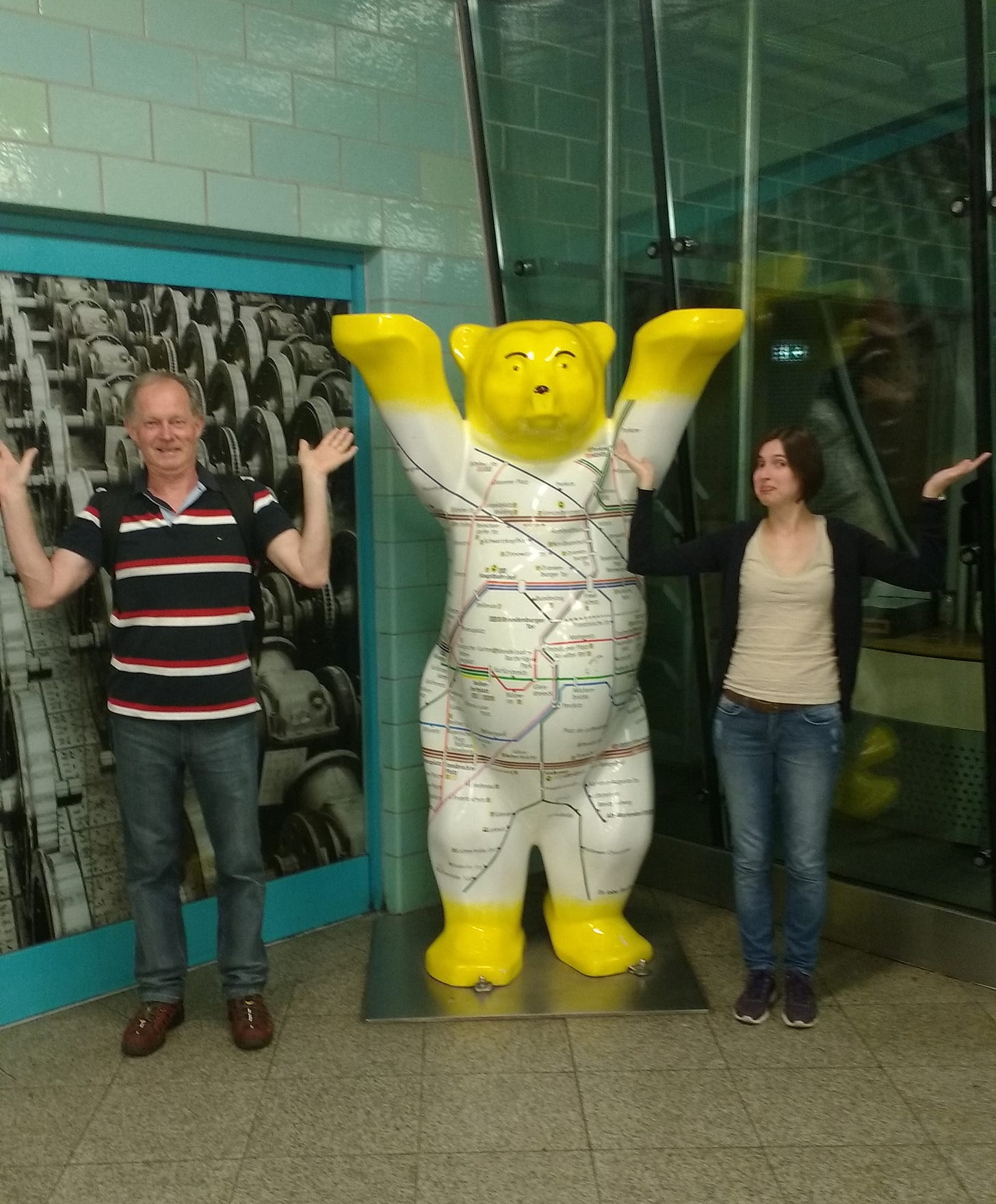Foto de uma estátua de urso com as garras para cima. Meu pai e eu, cada um do lado do urso, imita a pose dele