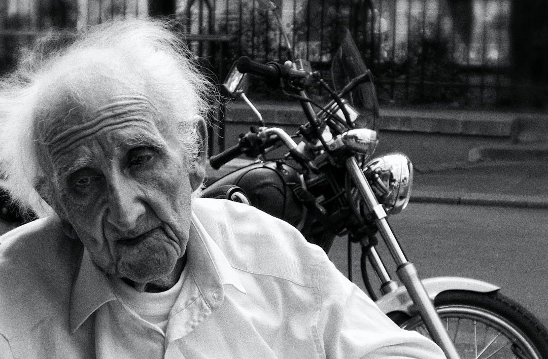 man wearing dress shirt near motorcycle