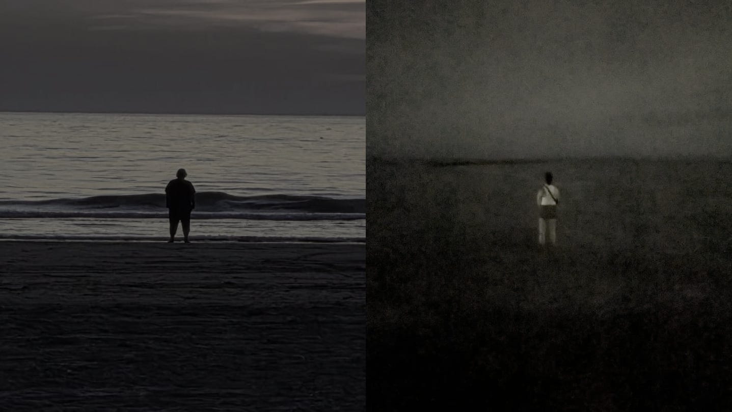 Two people standing on the beach at night, looking into the distance at the moon