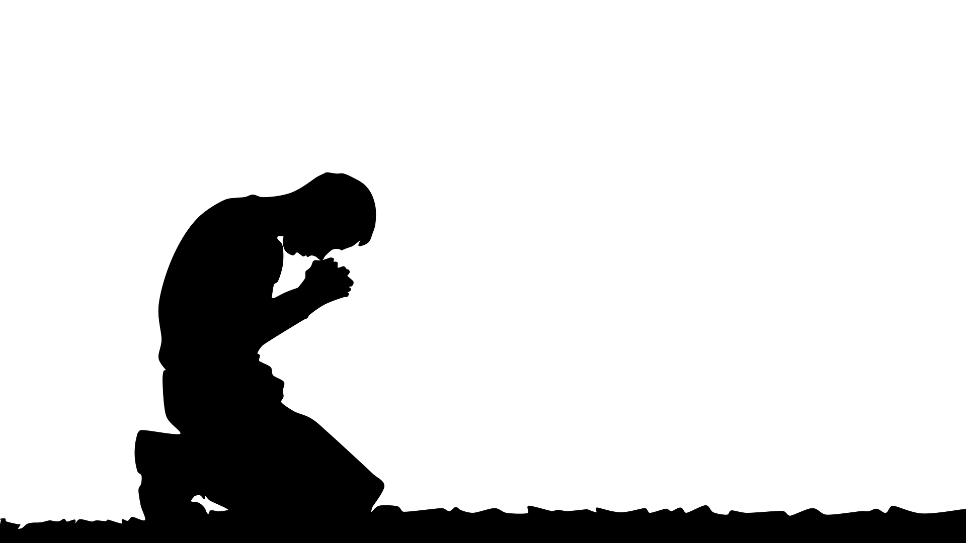 Silhouette of man praying in kneeling position