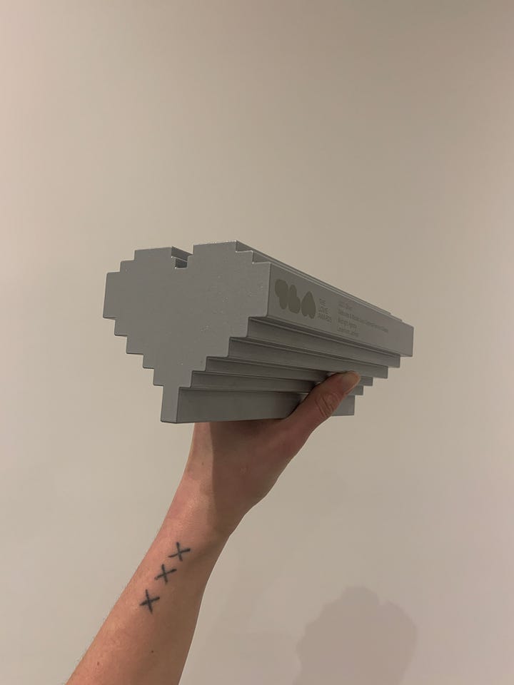 x2 images of a silver, metal award statue in the shape of a pixelated heart