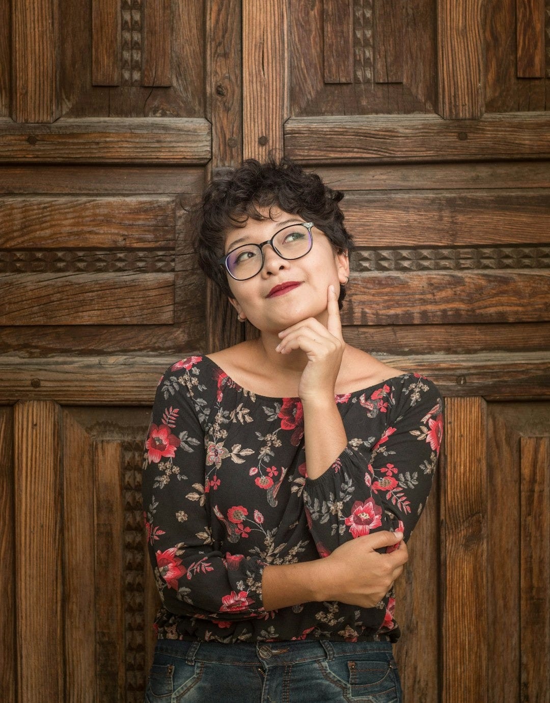 woman leaning against door while holding her cheek