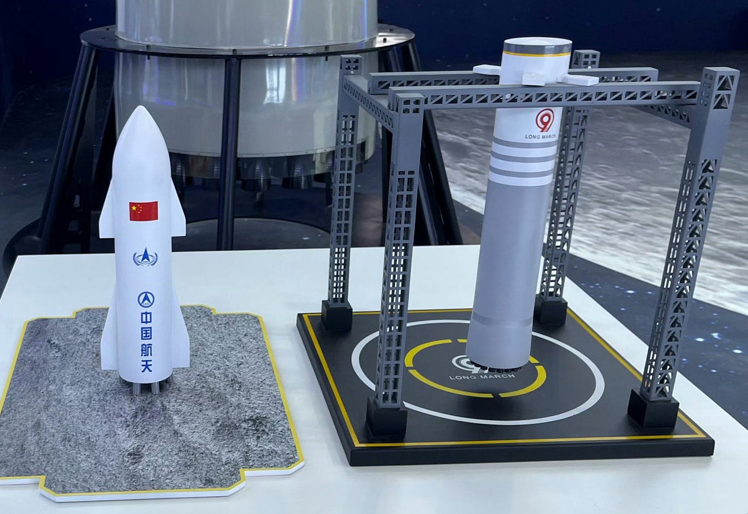 A display of the Long March 9’s reusable upper-stage (left) and its reusable first-stage being caught on a moving rail system. A display of the Long March 9’s reusable upper-stage (left) and its reusable first-stage being caught on a moving rail system.