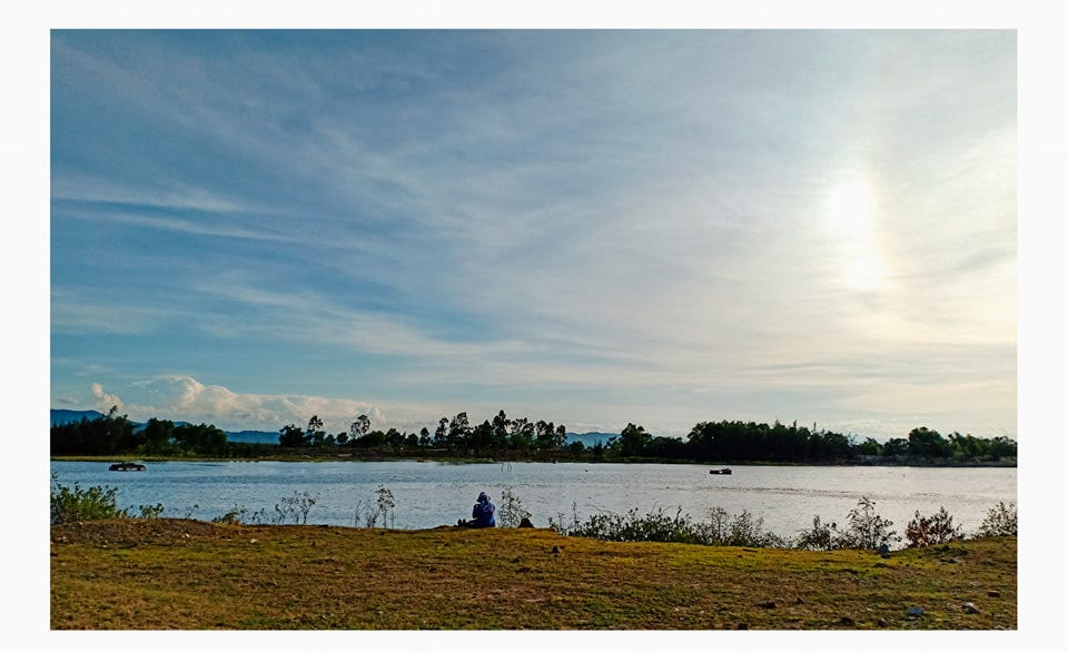 May be an image of 1 person, lake, nature and sky