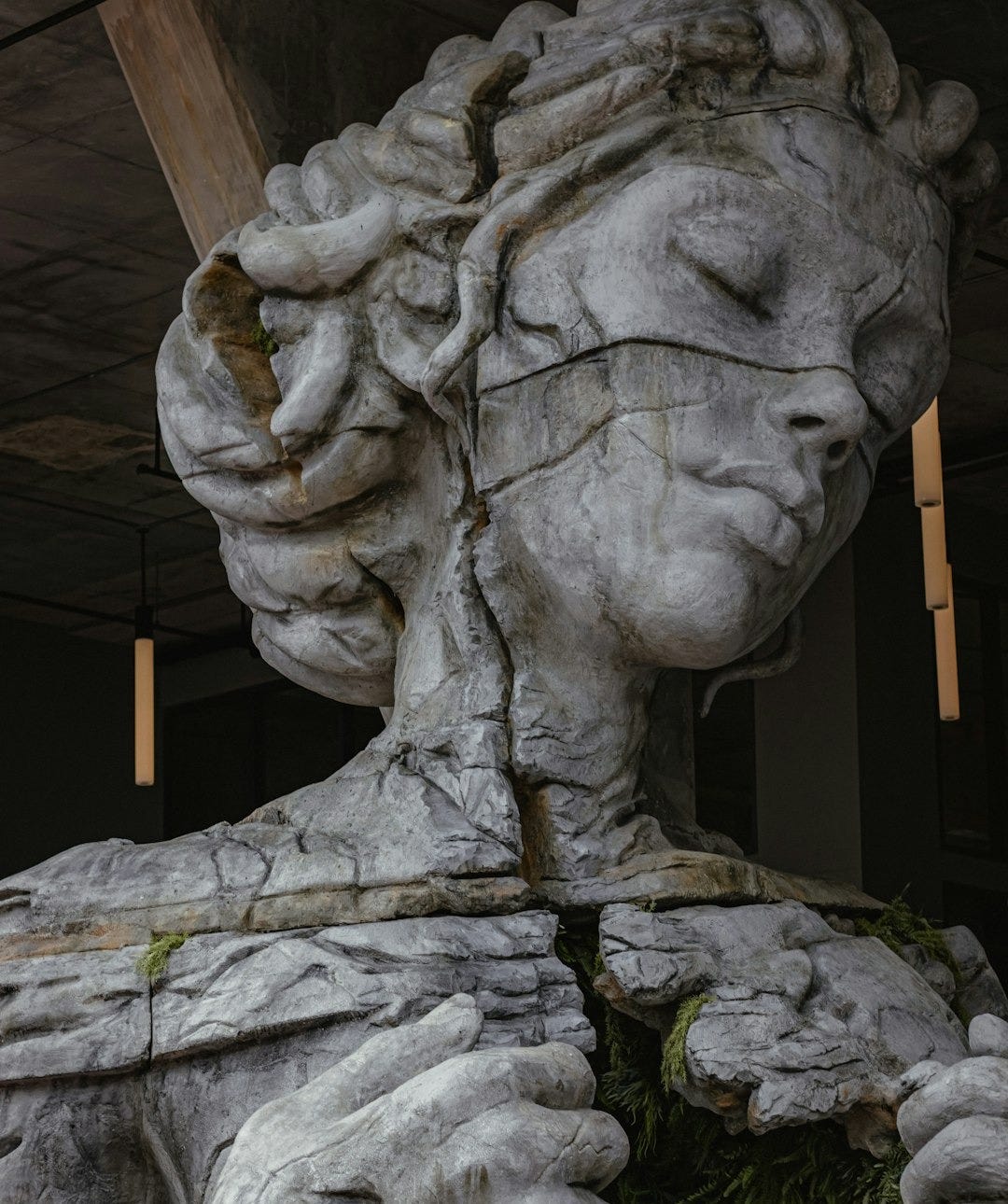 gray concrete statue of man holding stick