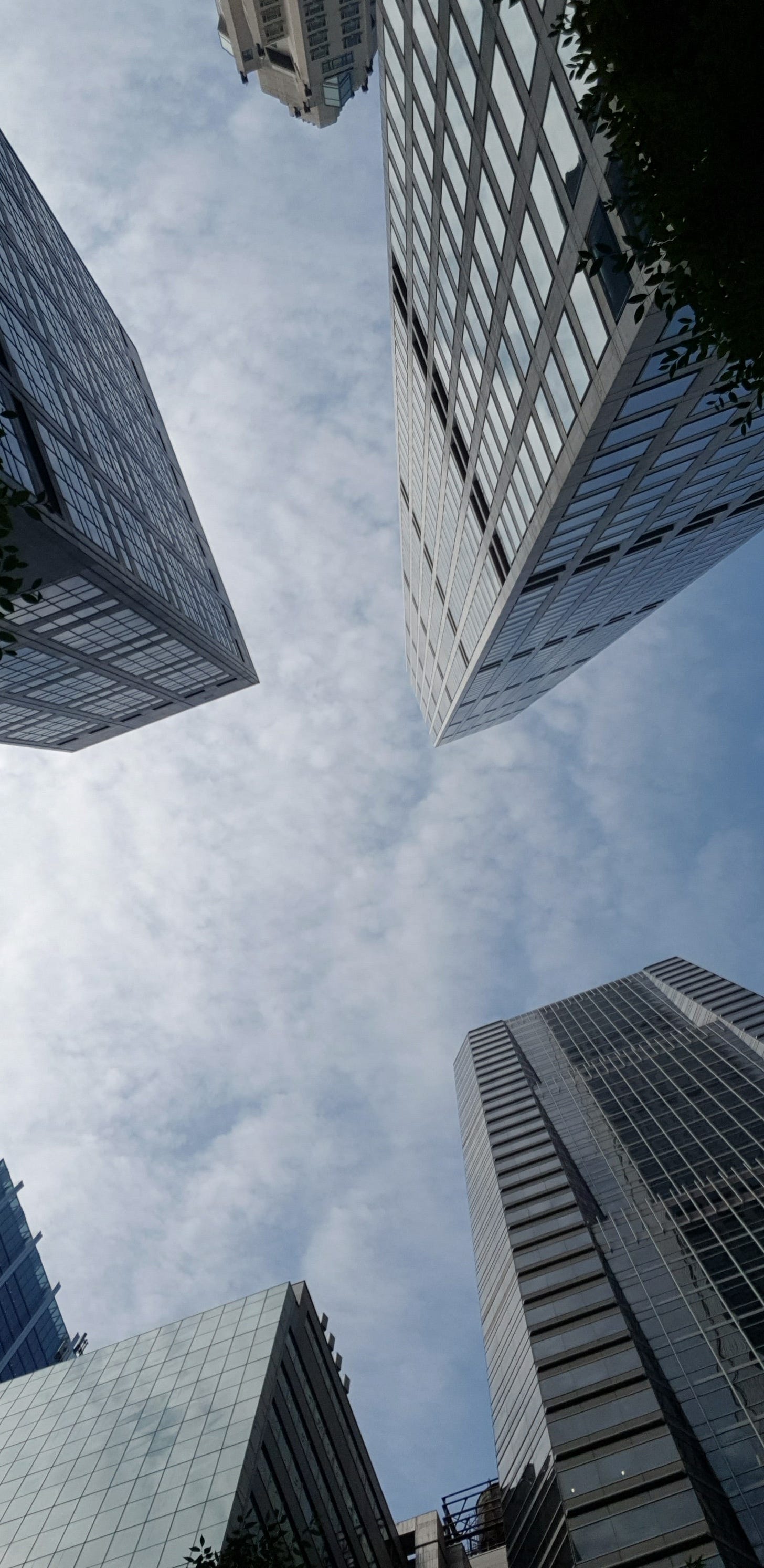 仰望數棟摩天大樓在陰天下交會收束。 仰望數棟摩天大樓在陰天下交會收束。