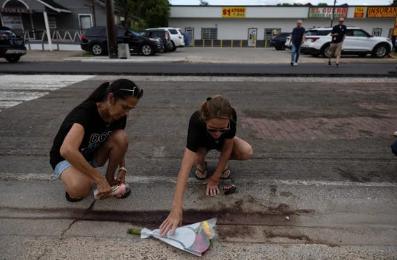 Two women place a candle next to flowers near the scene where an ICE agent fatally shot a Mexican motorist, identified as Lorenzo Salgado Araujo, during a vehicle stop in Houston, Texas, US, on July 7, 2026 [Antranik Tavitian/Reuters]
