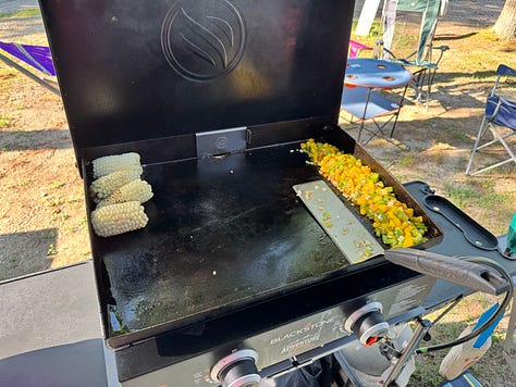 A blackstone griddle, cooking various meals, and a fire ring with marshmallows and a chocolate center