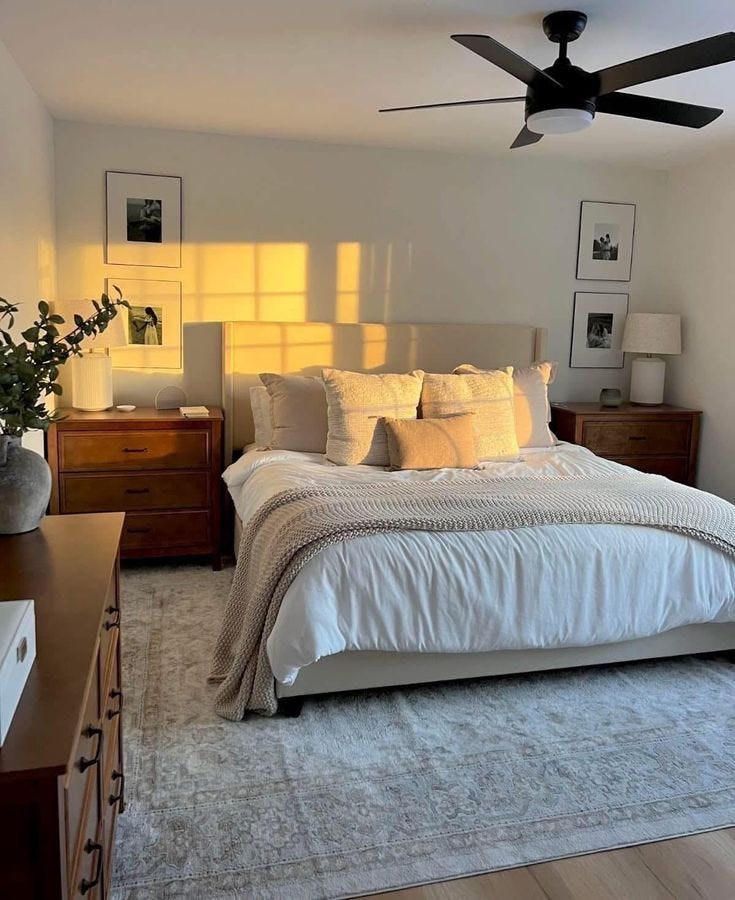 This may contain: a bedroom with a bed, dressers and ceiling fan in it's center