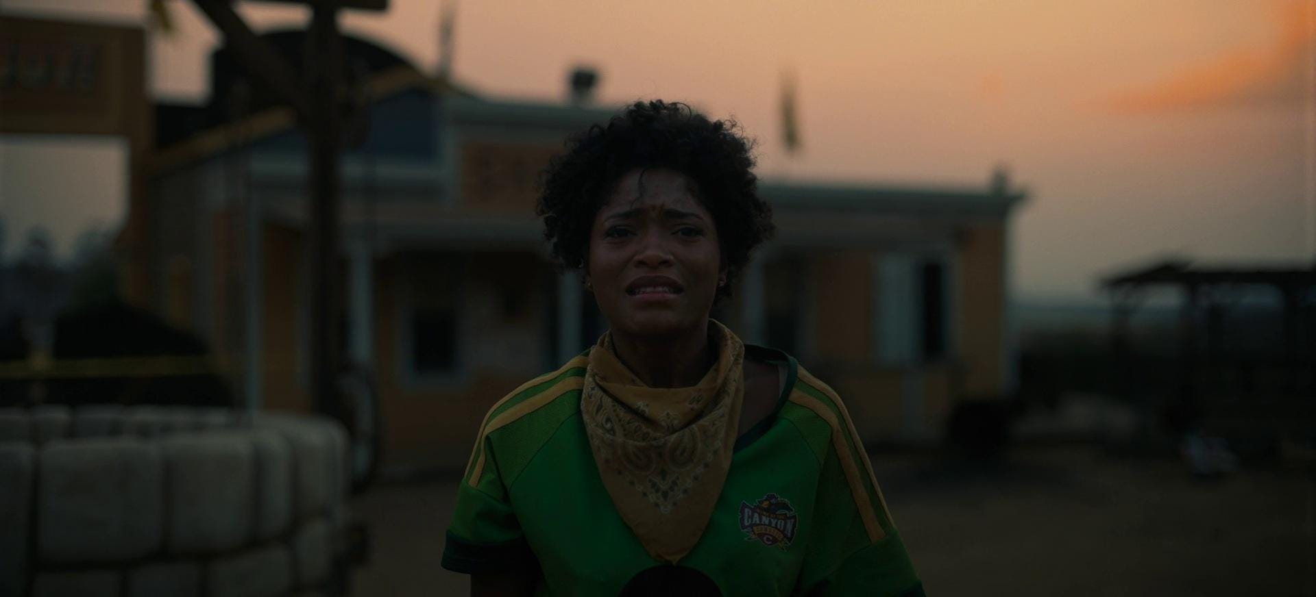 Screenshot from "Nope." The character Emerald, with blood on her lips, appears exhausted and sad.