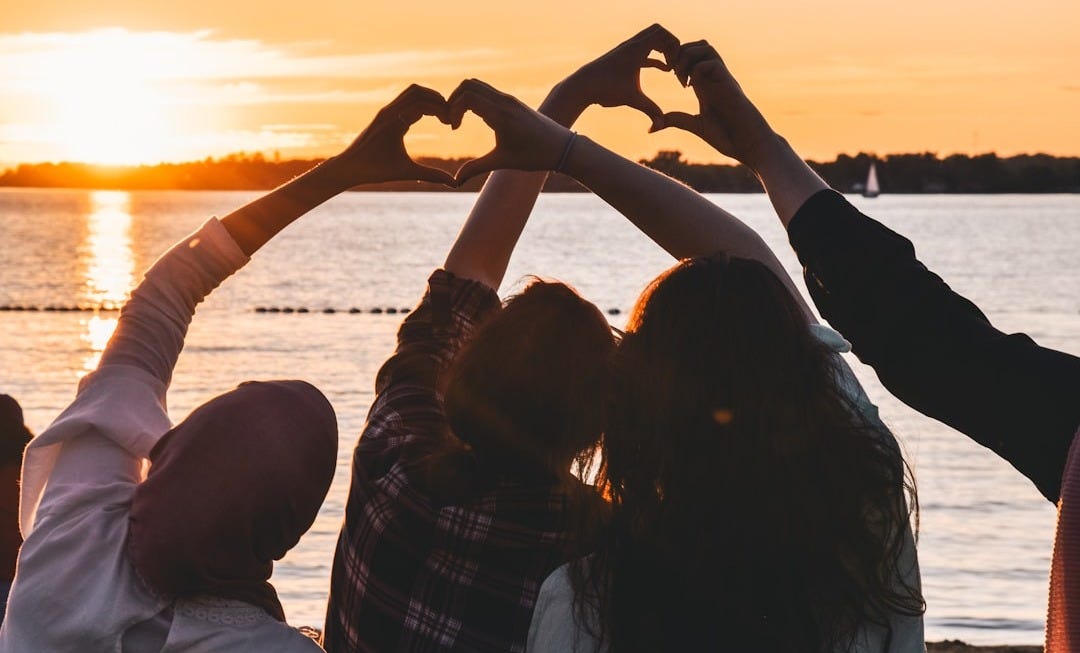 people near body of water during golden hour