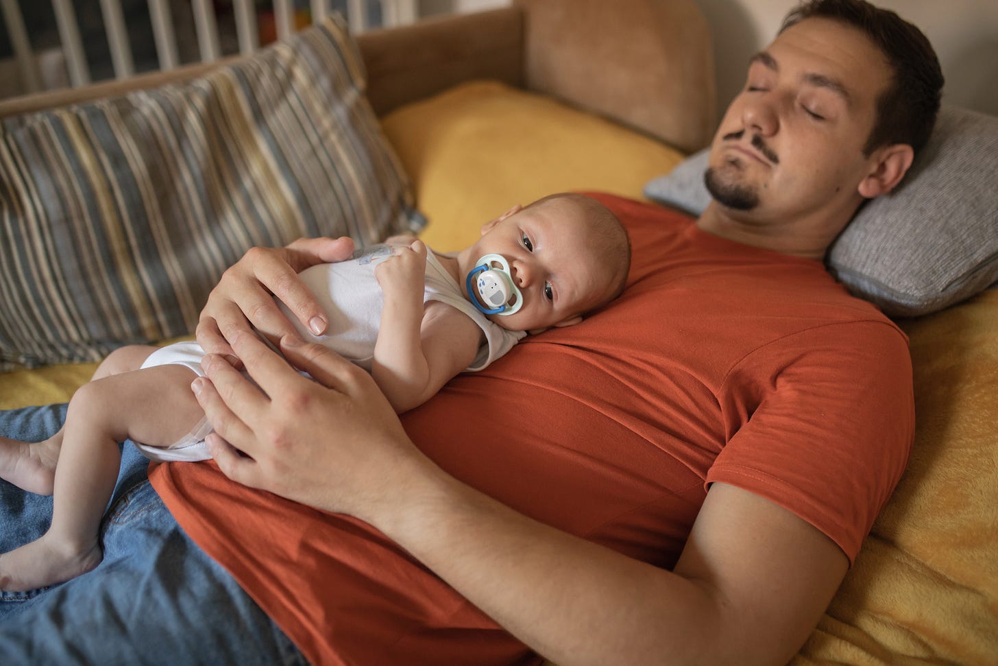 Sleeping father holding sleepy baby on his chest Sleeping father holding sleepy baby on his chest