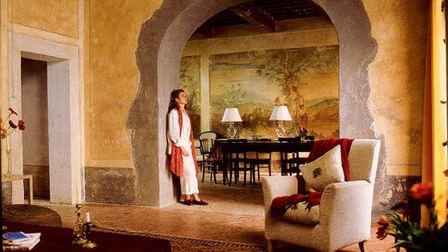 This may contain: a woman standing in a living room next to a table