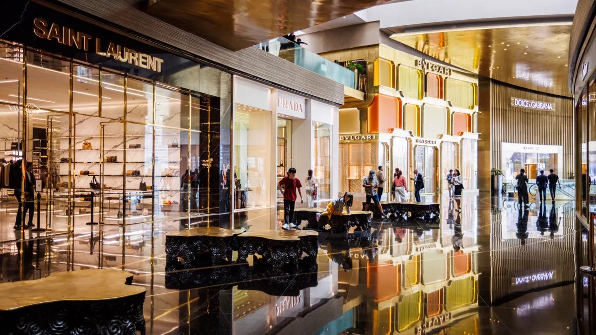 A gold mall interior features many high-end luxury storefronts. A gold mall interior features many high-end luxury storefronts.