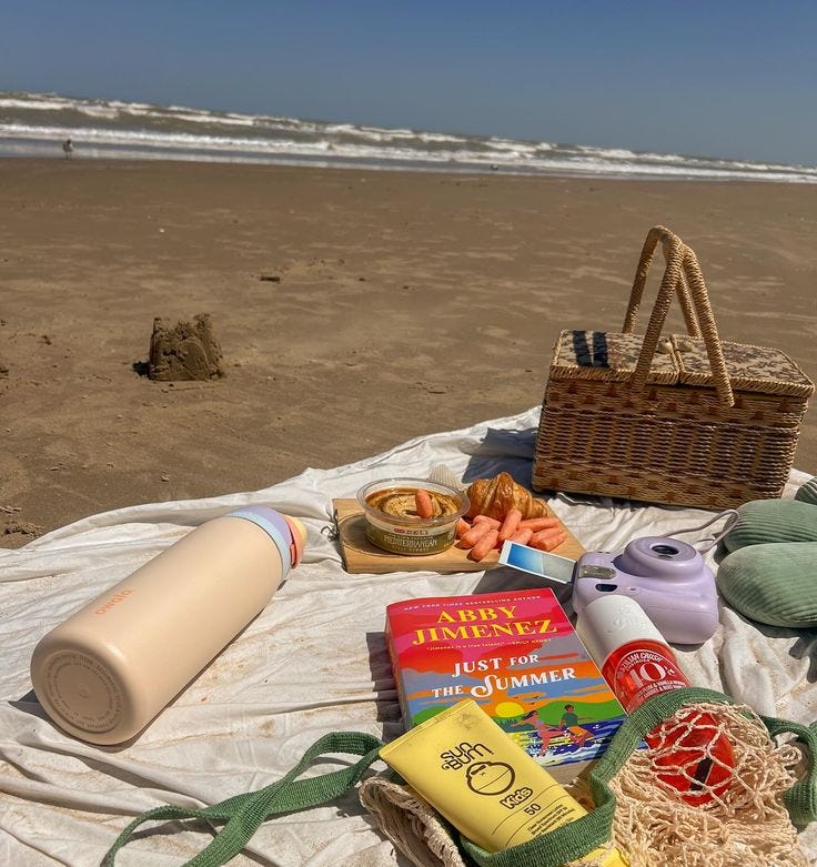 This may contain: the picnic is set out on the beach with food and drinks in front of it