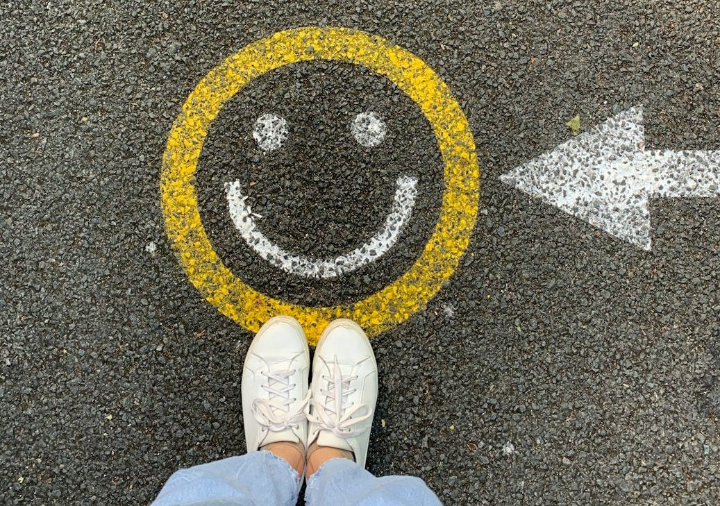 person in white shoes standing on gray concrete road person in white shoes standing on gray concrete road