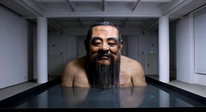 Huge lifelike statue of Confucius in the bathtub.