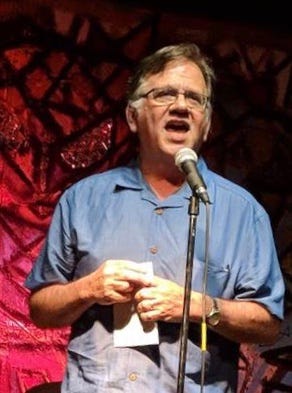 poet Chuck Joy speaking at a microphone. poet Chuck Joy speaking at a microphone.