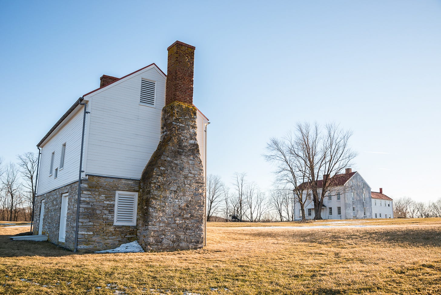 A house with a chimney in the middle of a field