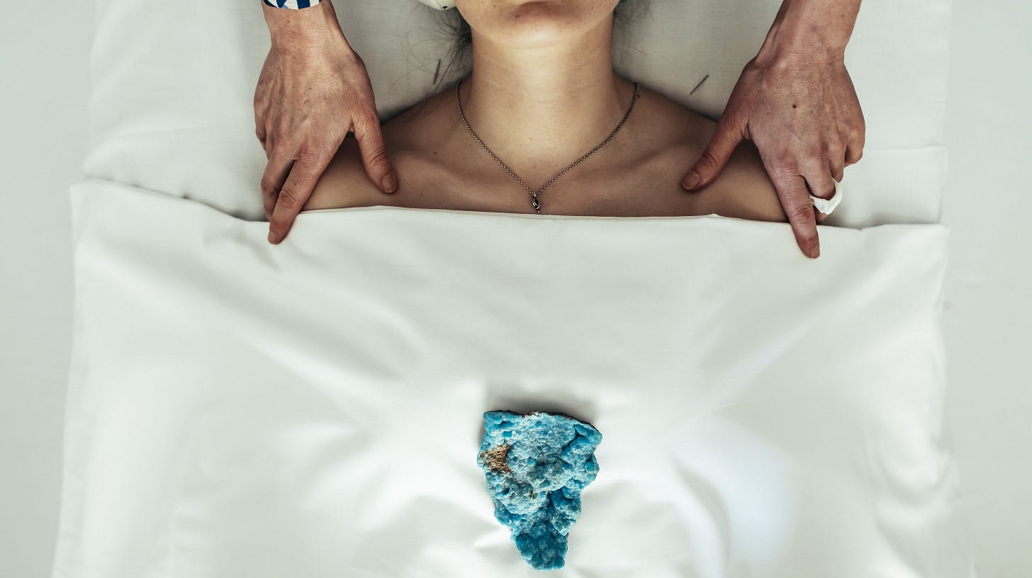 Acupuncture patient with turquoise stone on treatment table, Dr. Catherine's hands resting at shoulders — Newport clinic