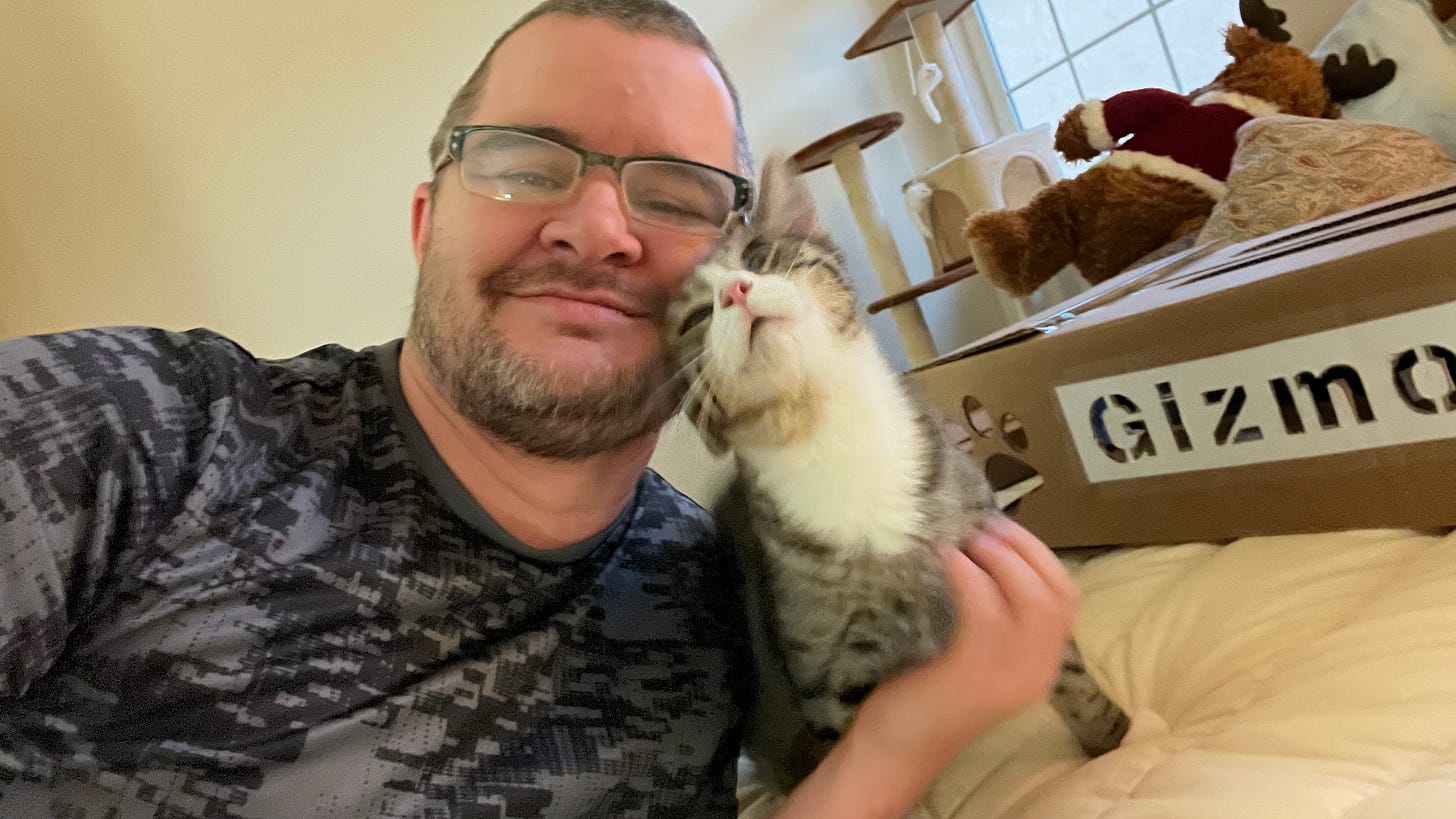 Extremely handsome man cuddling with a cute tabby cat