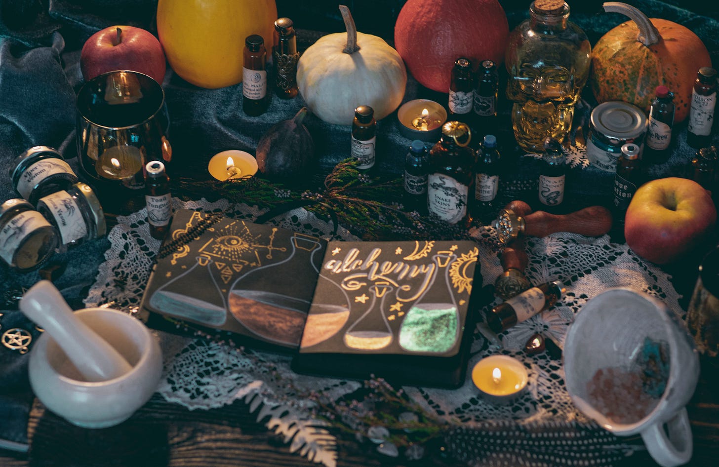 A richly detailed alchemy-themed still life featuring an illustrated notebook labeled “alchemy,” surrounded by small potion bottles, candles, pumpkins, apples, herbs, and a mortar and pestle. The scene is lit warmly and evokes mystery, transformation, and ancient ritual. A richly detailed alchemy-themed still life featuring an illustrated notebook labeled “alchemy,” surrounded by small potion bottles, candles, pumpkins, apples, herbs, and a mortar and pestle. The scene is lit warmly and evokes mystery, transformation, and ancient ritual.