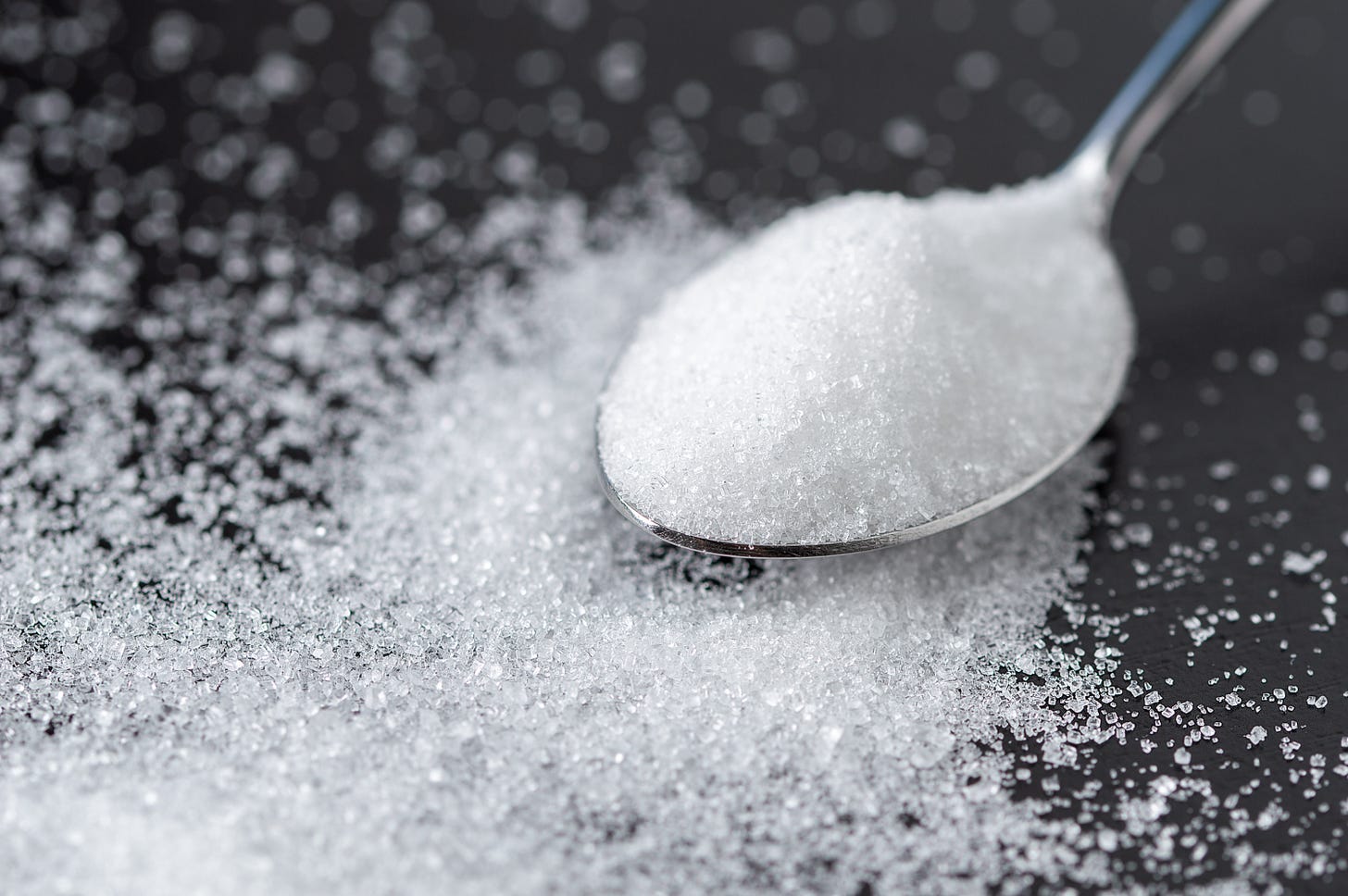 Spoonful of sugar on black background