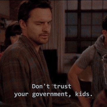 This may contain: two men standing next to each other in front of a tv screen with the words don't trust your government, kids