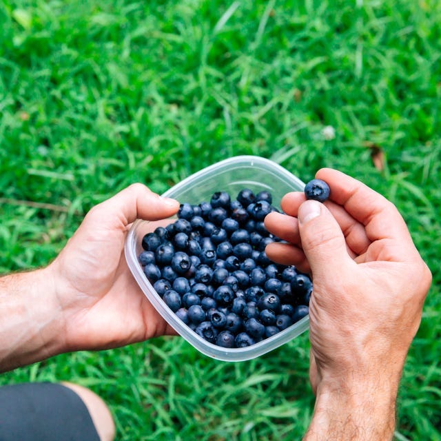 closeup of man eating blueberries outside in nature healthy eating concept of man hiking with blueberry summer fruits to eat for healthy snack and snacking, antioxidants and superfoods, or ready toeat foods blueberries are in plastic container and there is a reusable plastic water bottle in frame unrecognizable man outdoors part of a series closeup of man eating blueberries outside in nature healthy eating concept of man hiking with blueberry summer fruits to eat for healthy snack and snacking, antioxidants and superfoods, or ready toeat foods blueberries are in plastic container and there is a reusable plastic water bottle in frame unrecognizable man outdoors part of a series